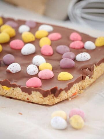 The easiest No-Bake Easter Egg Slice you'll ever make! A biscuit base filled with your favourite mini Easter eggs, topped with a chocolate layer and even more Easter eggs!