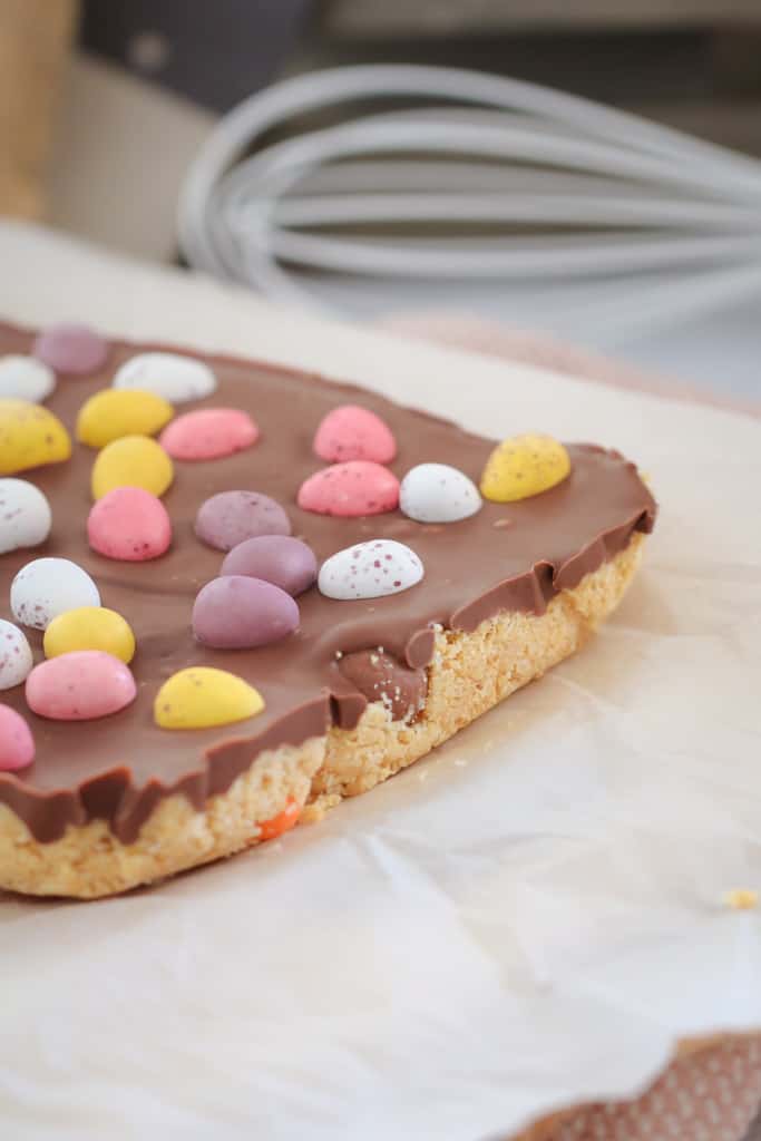 Easter eggs on top of a biscuit slice with milk chocolate. 