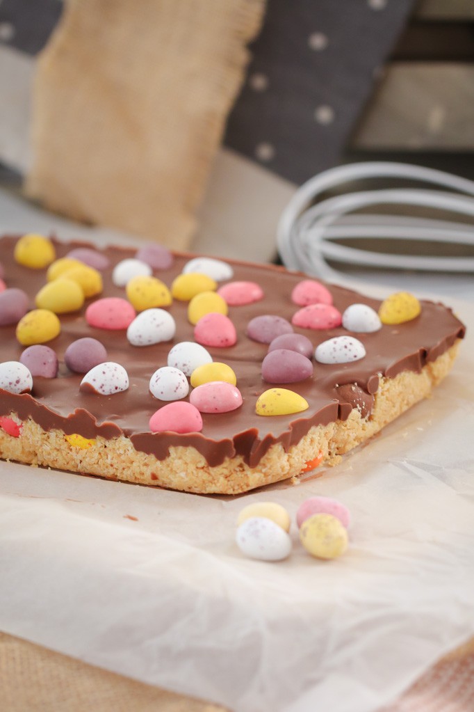 Pink, white and yellow chocolate easter eggs on a unbaked slice. 