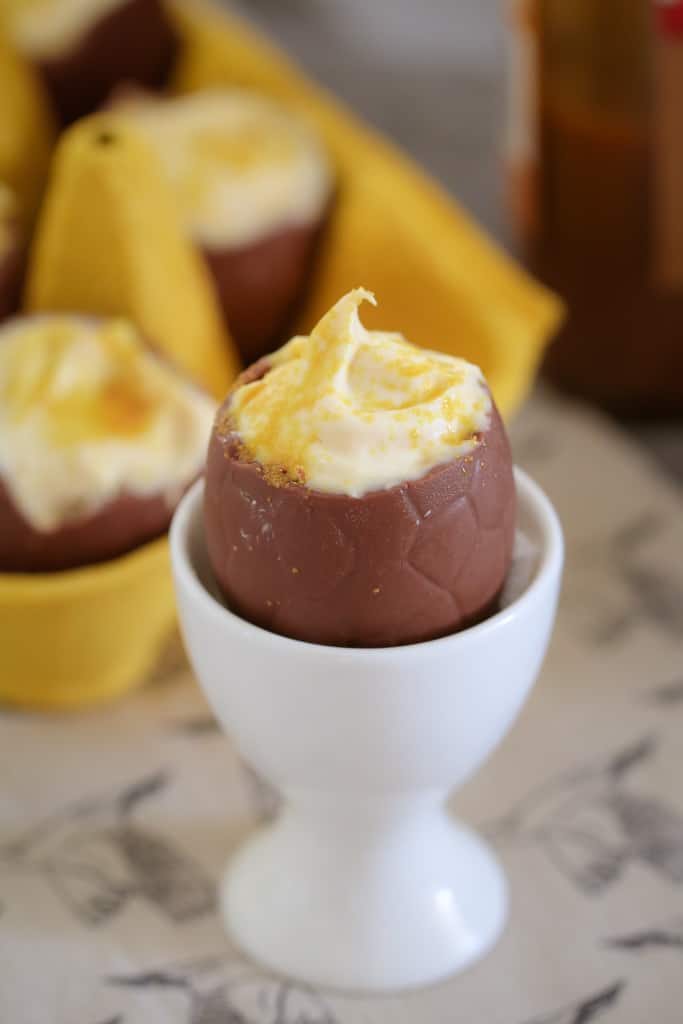 An egg cup with a chocolate easter egg filled with mousse.