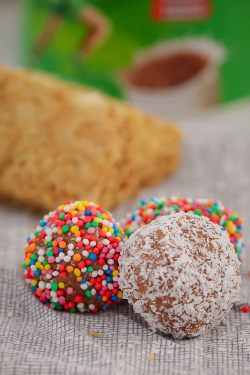 A close up of round balls decorated in coloured sprinkles and coconut