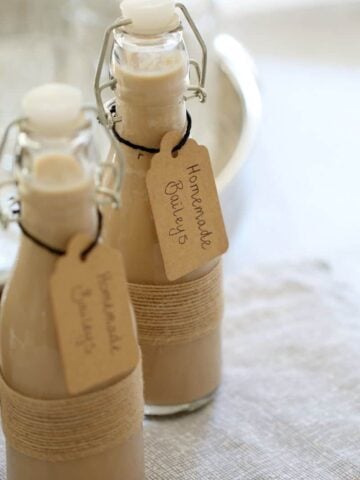 Two small bottles filled and with a label attached saying Homemade Baileys