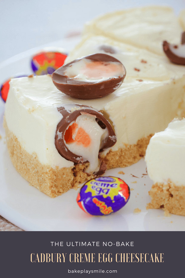 A serve of a white cheesecake with a Cadbury Creme Egg split on top, and wrapped Cadbury Creme Eggs nearby