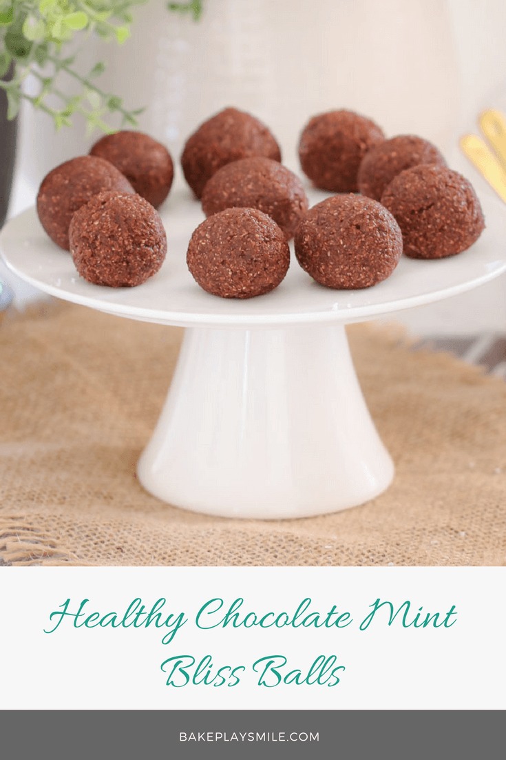Round chocolate bliss balls on a white cake stand