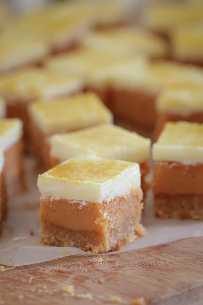 A wooden board covered with little squares of caramel slice