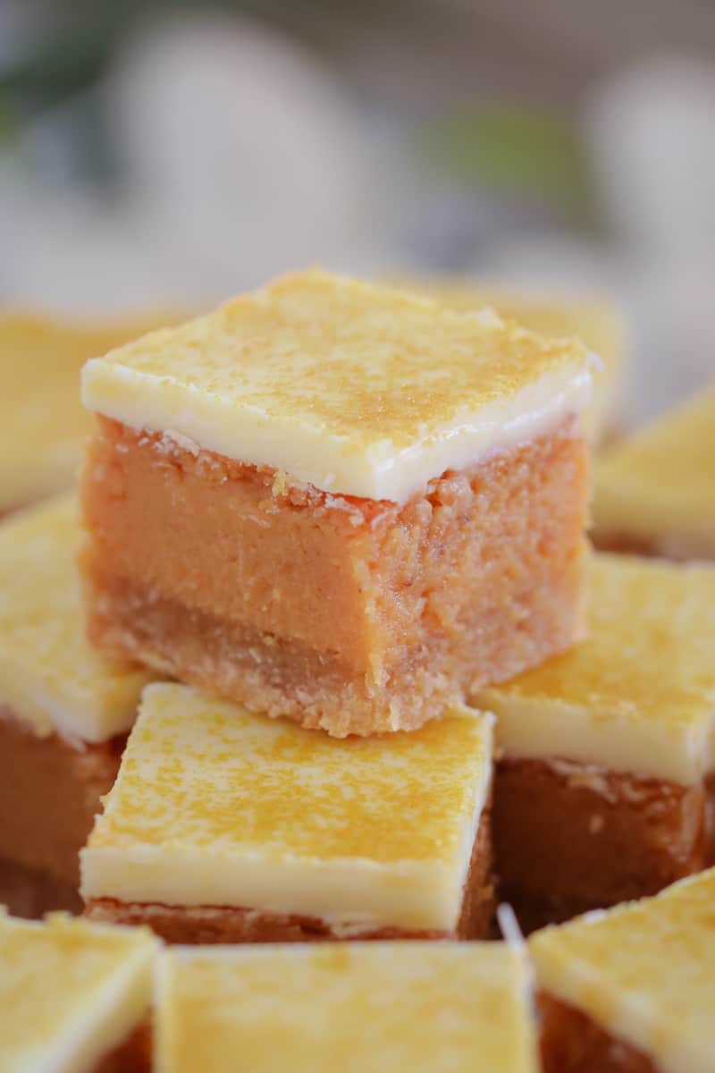 A close up of a stack of small squares of caramel slice topped with white chocolate