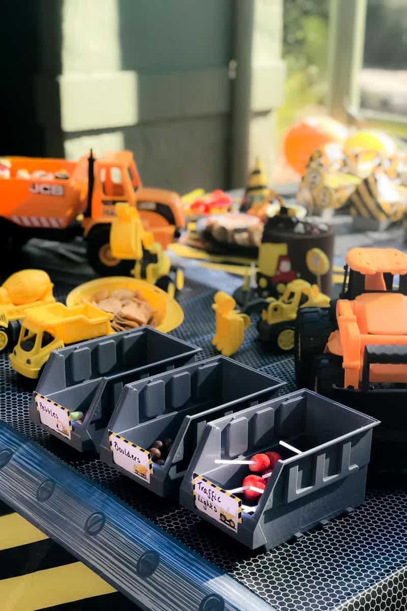 Mini toy trucks, graders and trays in front of Digger party food