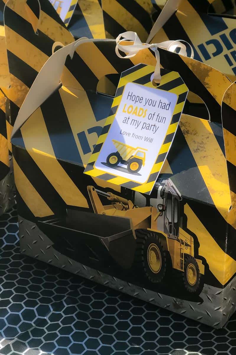 A close up of a yellow and black stripped party box with a picture of a truck on the side and a label attached