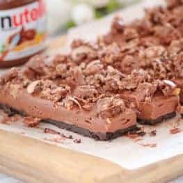 The ultimate no-bake Chocolate Nutella Cheesecake Slice... made with a Oreo biscuit base, a rich chocolate Nutella cheesecake filling and topped with crushed Ferrero Rochers. A chocoholics delight!
