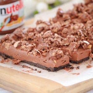 The ultimate no-bake Chocolate Nutella Cheesecake Slice... made with a Oreo biscuit base, a rich chocolate Nutella cheesecake filling and topped with crushed Ferrero Rochers. A chocoholics delight!