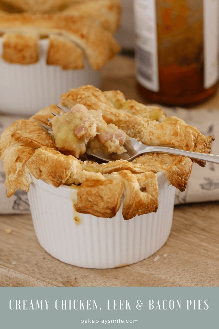 A fork in a pie with the pastry top overlapping sides of a white individual ramekin