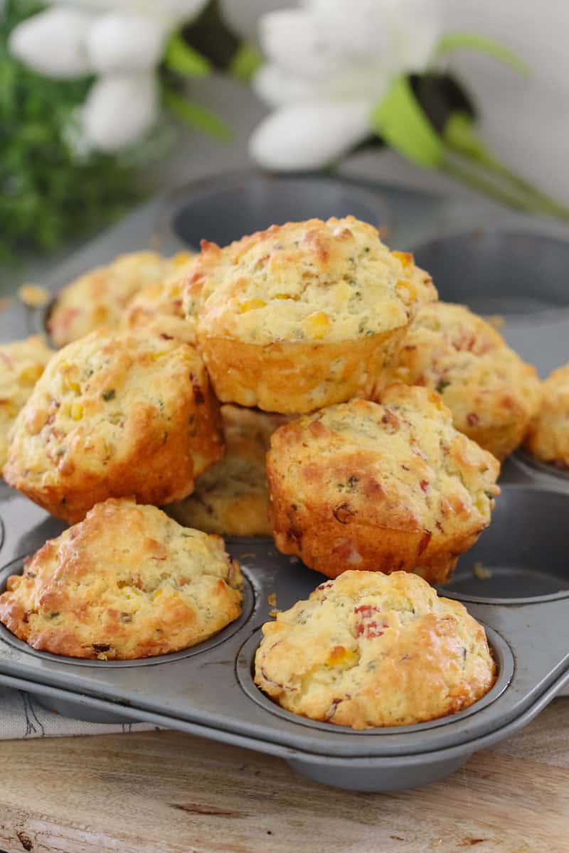 A stack of savoury muffins piled on a muffin baking tray