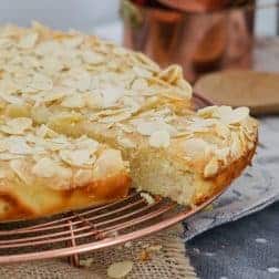 One serve slightly removed from a golden almond and ricotta cake