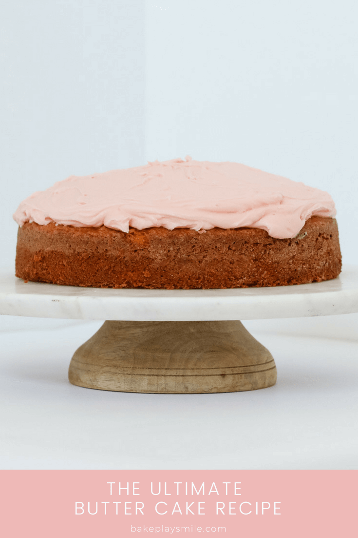 A butter cake on a cake plate covered in pink buttercream.