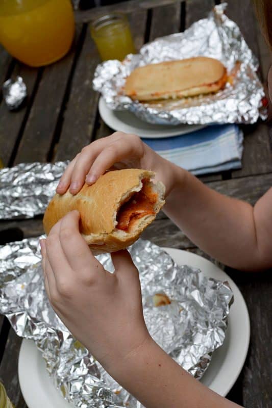 Pizza rolls being unwrapped from foil and eaten while camping. 