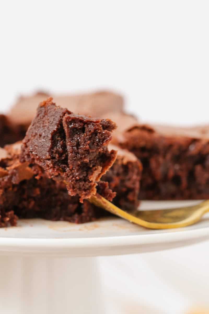 A gluten free chocolate brownie being eaten off a fork.
