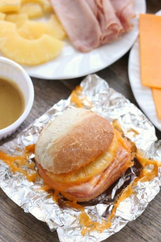 Ham, cheese and pineapple sandwiches wrapped in foil ready to be cooked. 