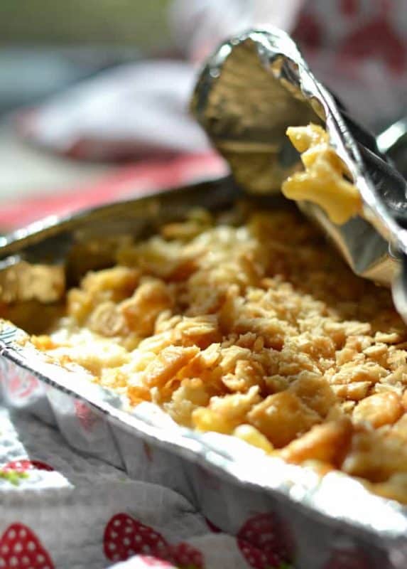 Macaroni and cheese in a foil pack being cooked on a campfire. 
