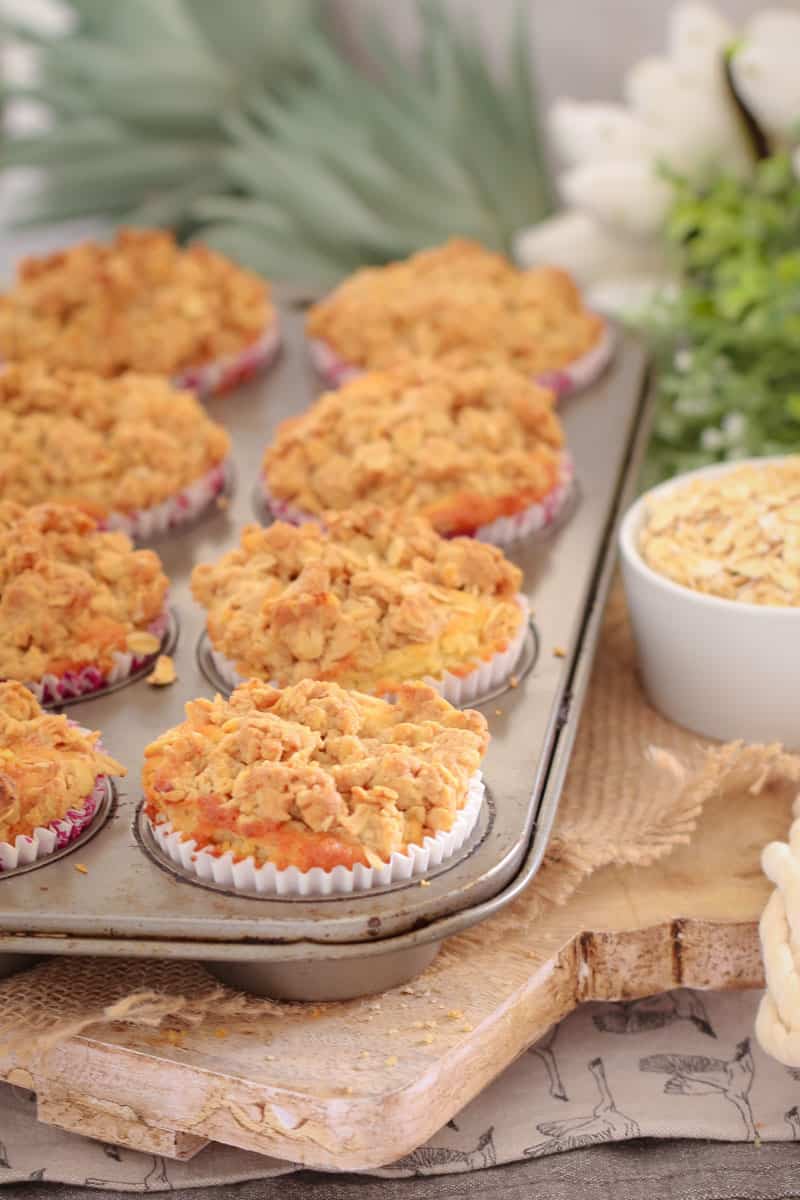 Muffins topped with crumble in a muffin tin.