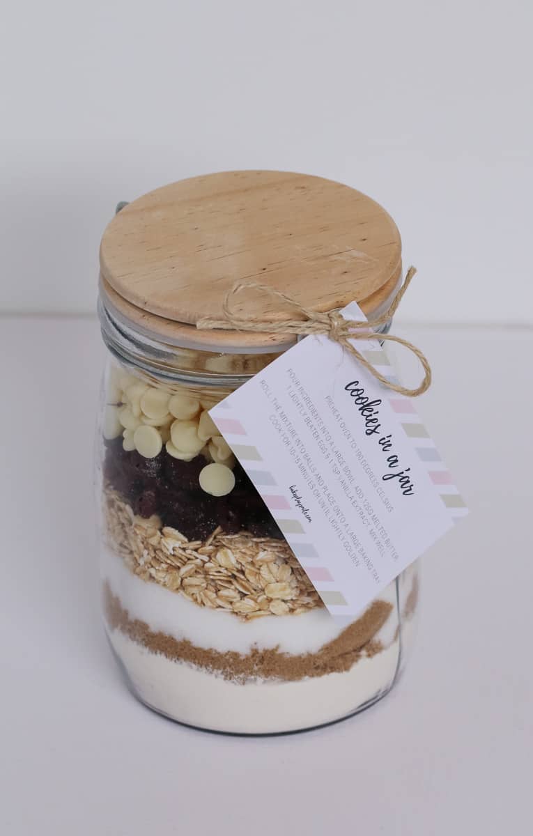 A lidded glass jar with a label attached, filled with layers of dry ingredients