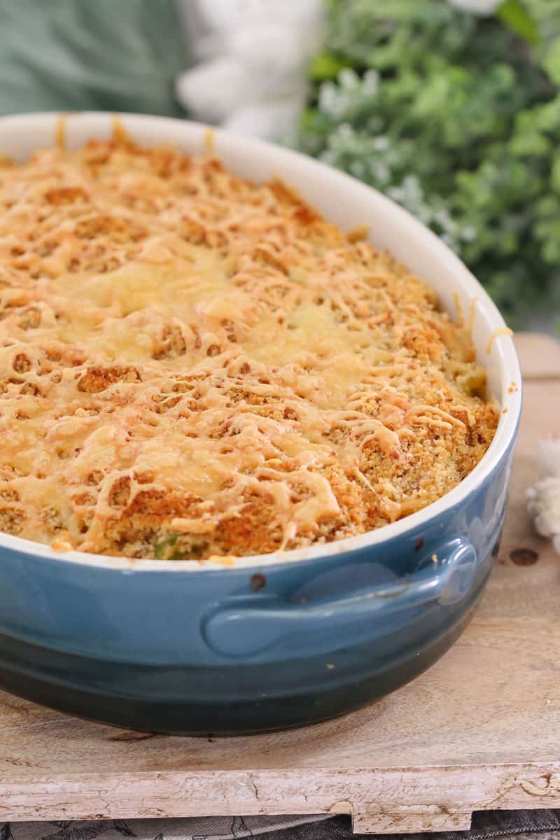 A blue baking dish of tuna pasta casserole topped with a crunchy cheese and breadcrumb topping