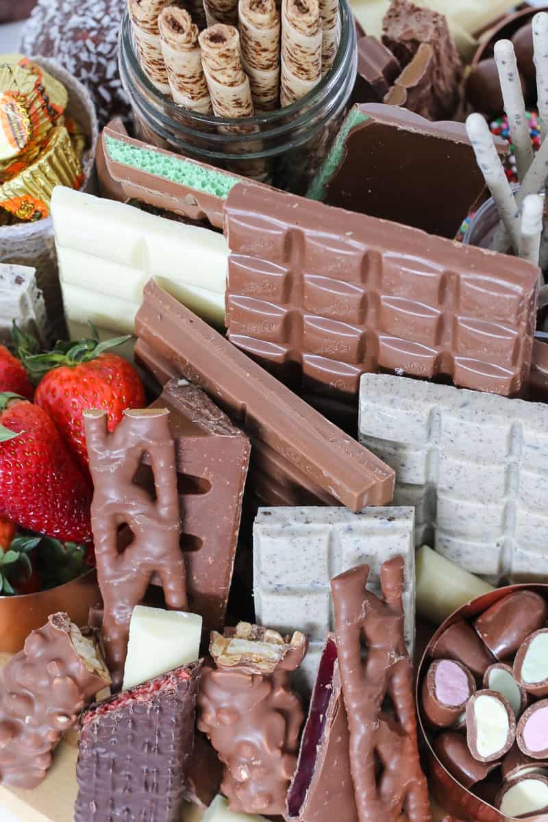 A variety of chocolate bars and treats, with fresh strawberries