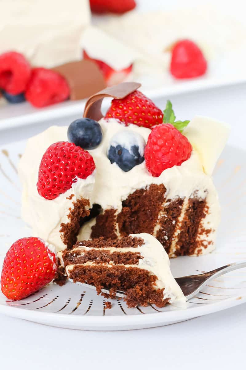 A piece Baileys Chocolate Ripple Cake, with berries on a plate with a fork