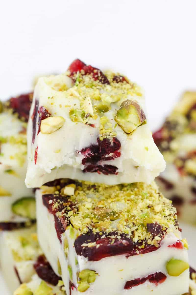 A close up of pieces of fudge made from white chocolate, cranberries and pistachios