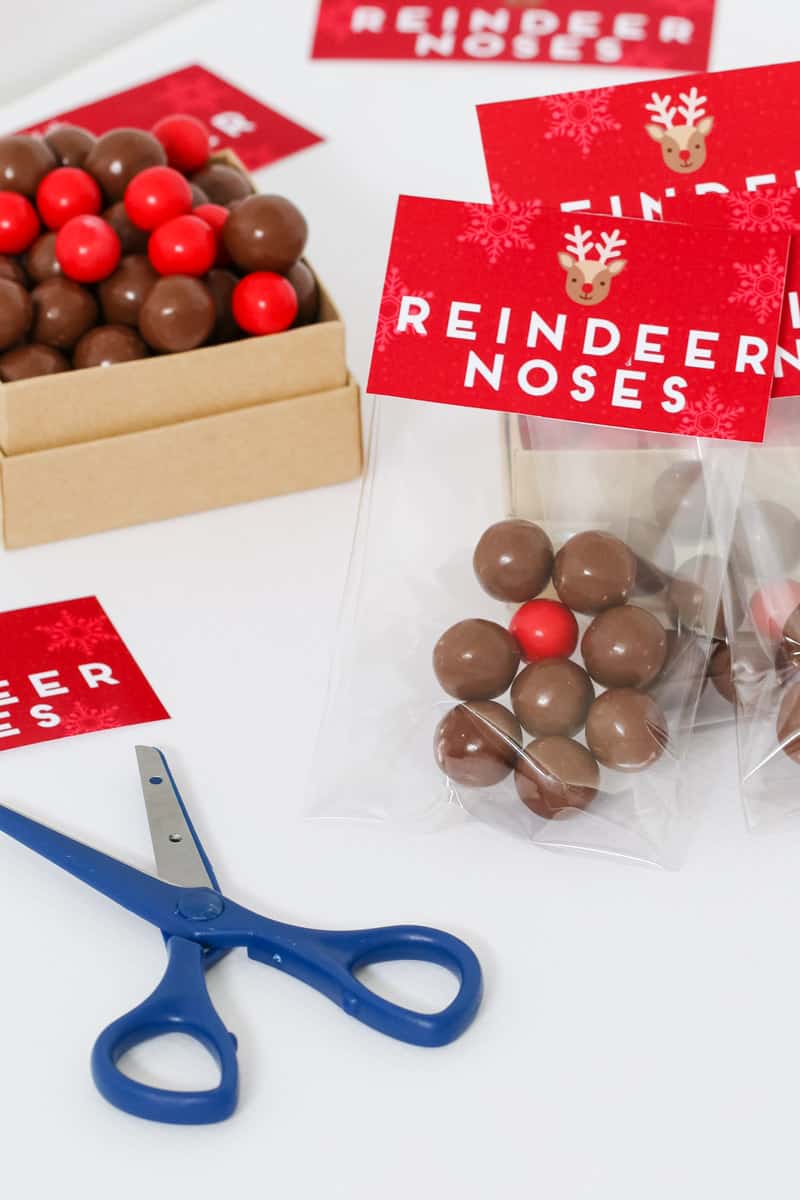 Bags filled with brown and red chocolate balls with red Christmas labels on them.