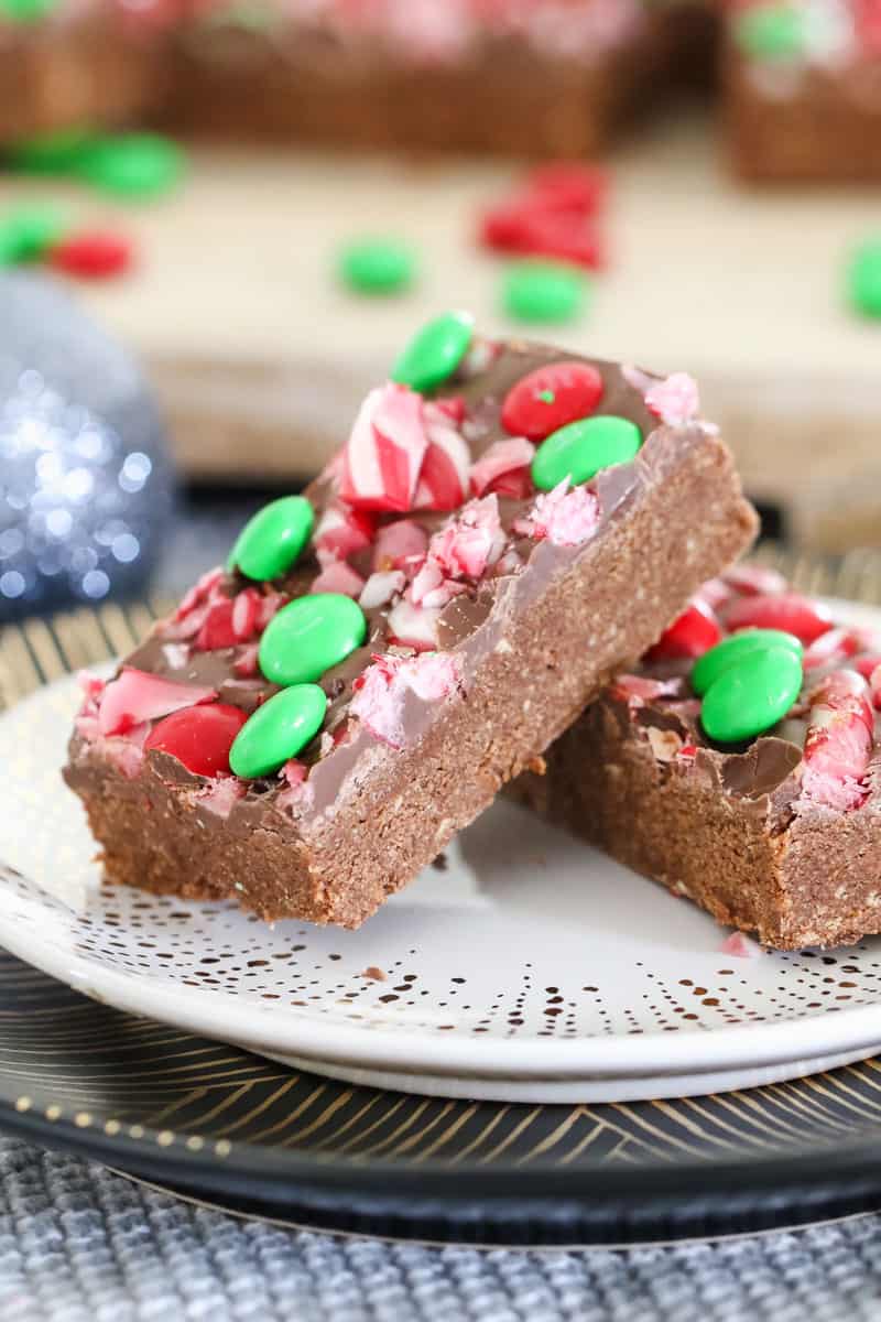 Two pieces of a chocolate slice, decorated with red and green lollies, on a plate