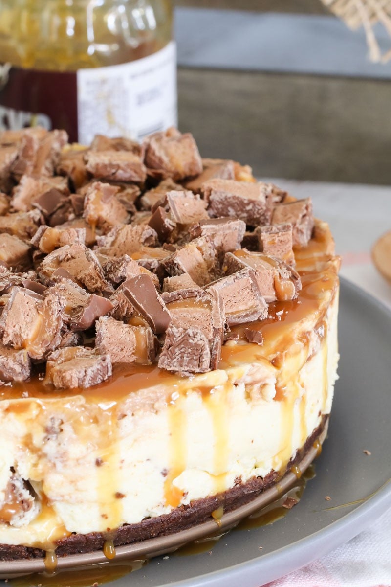 A close up of a cheesecake decorated with chopped Mars Bars