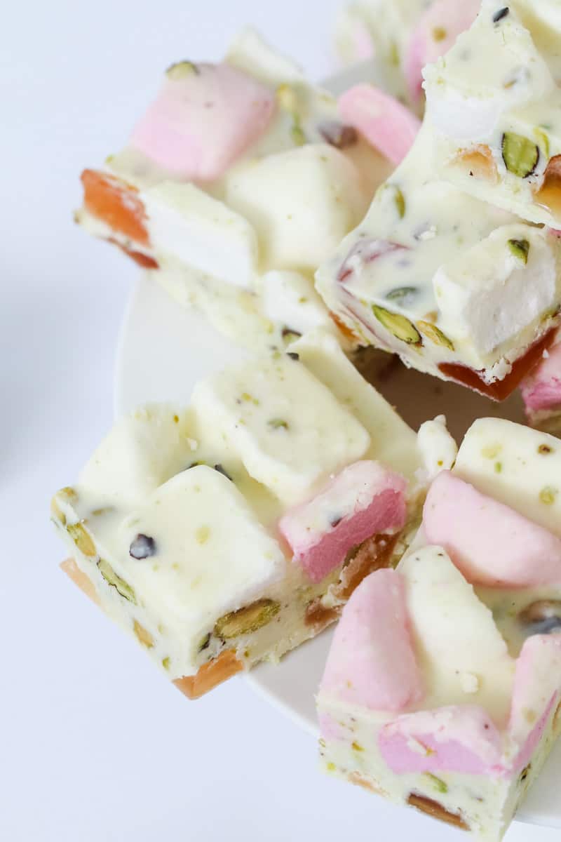 A close up of pieces of white Rocky Road filled with marshmallows, turkish delight and pistachios