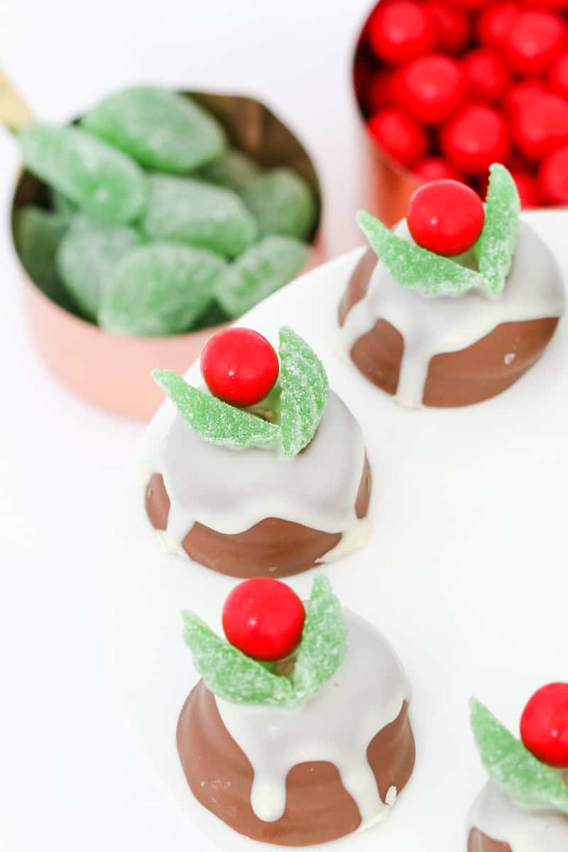 Chocolate Christmas puddings drizzled with white chocolate and decorated with spearmint leaves and red lollies