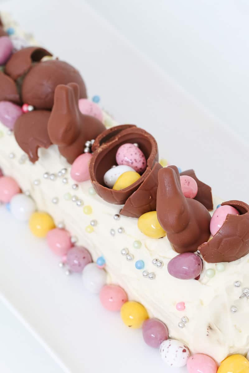 Easter eggs on top of a whipped cream and Arnott's chocolate ripple cake. 