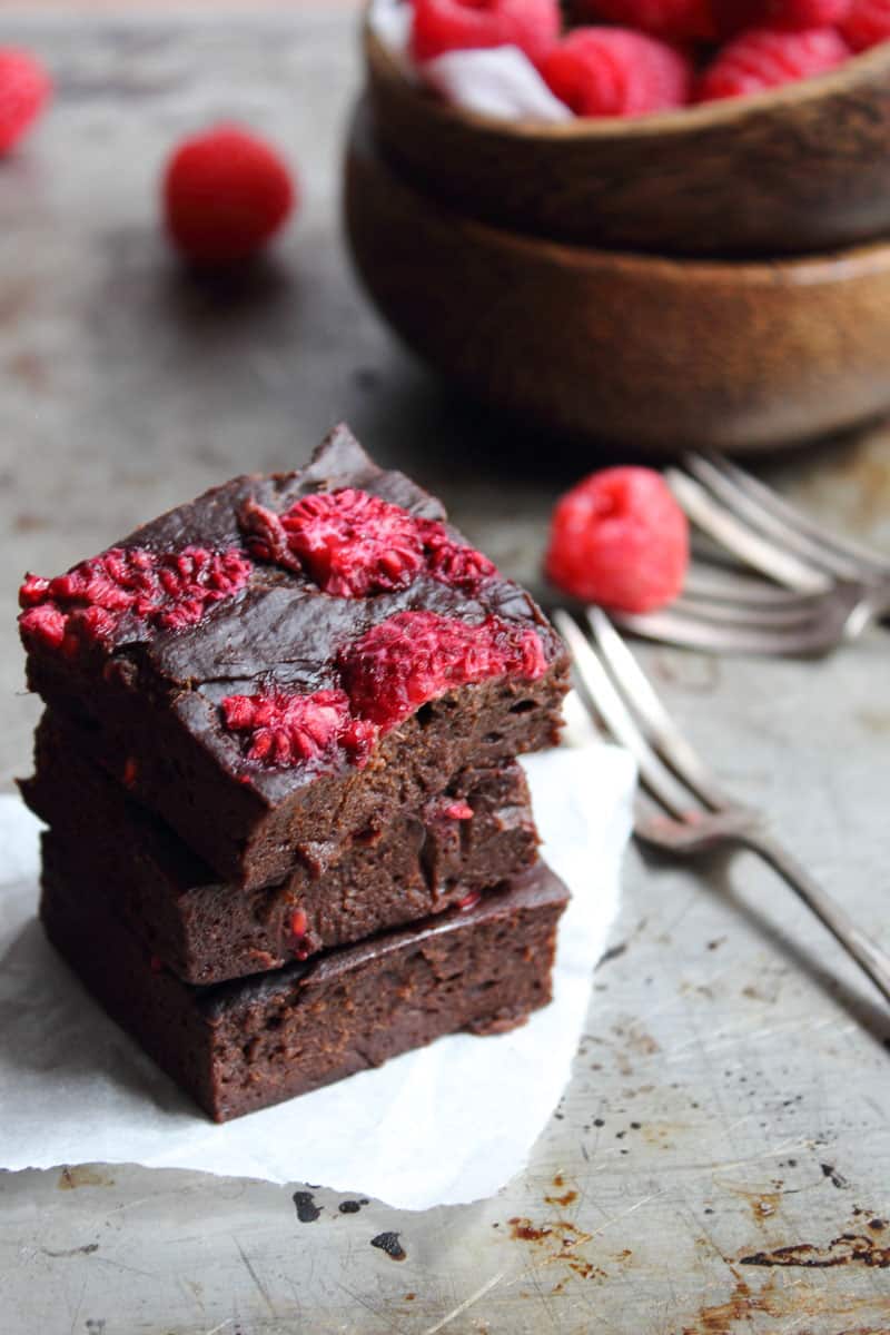 A stack of healthy chocolate brownies made with avocado, banana and raspberries. 