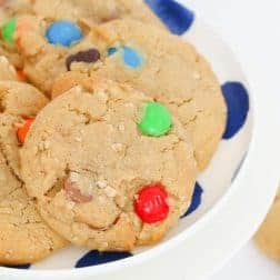 A plate of cookies with colourful M&Ms and chocolate chips.