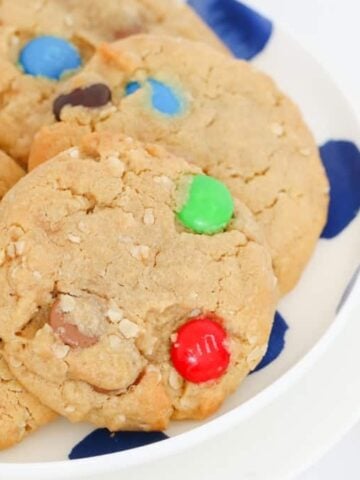 A plate of cookies with colourful M&Ms and chocolate chips.