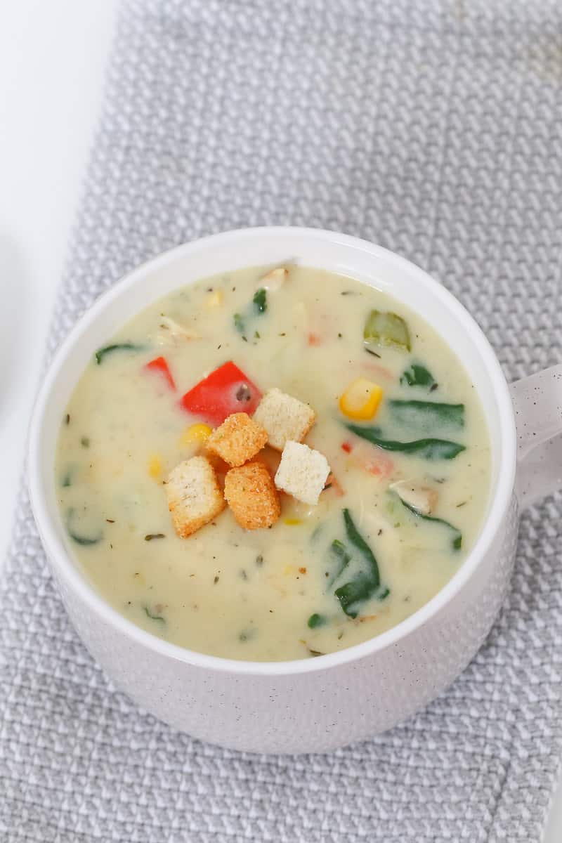 Vegetables in a cup of creamy soup with croutons.