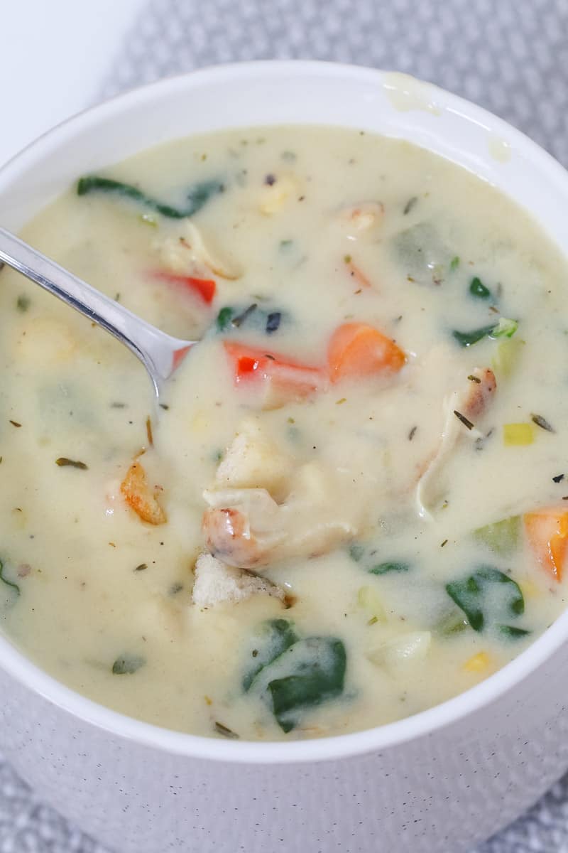 A spoonful of creamy chicken and vegetable soup. 