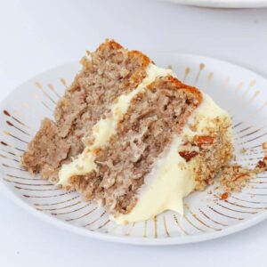 A slice of hummingbird cake on a white plate