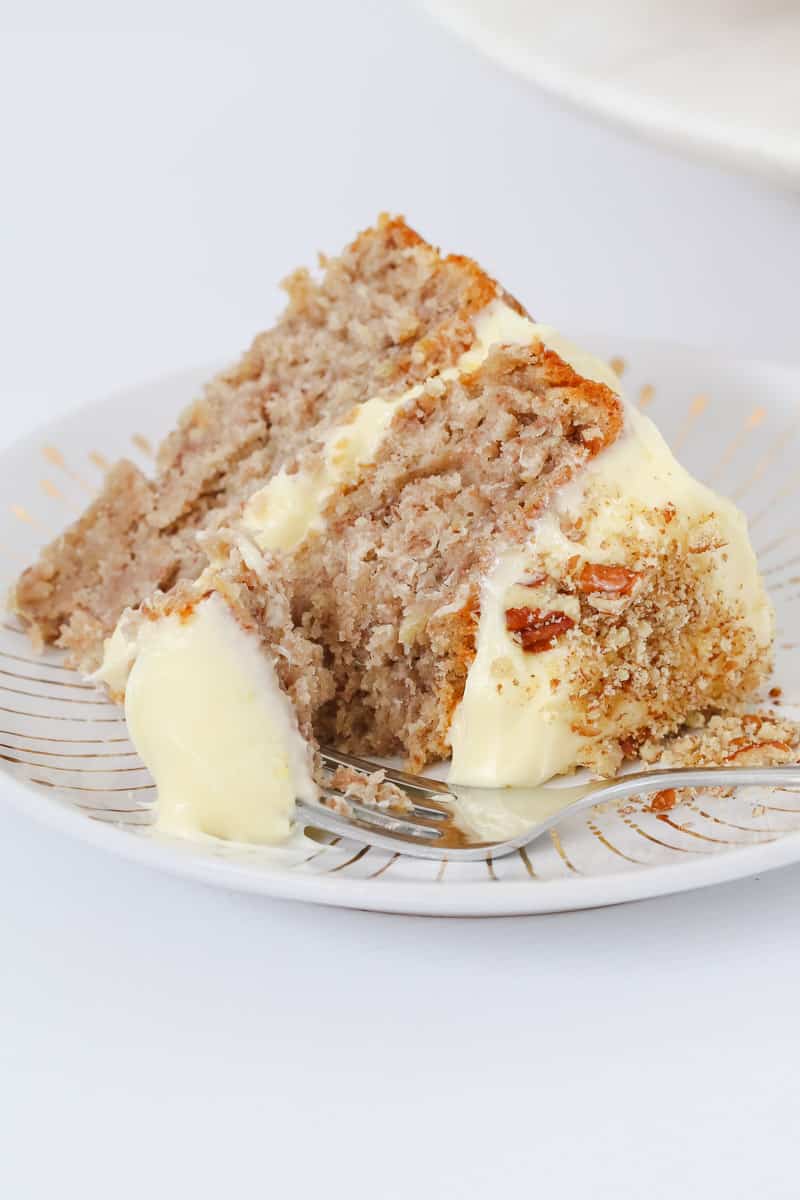 A serve of layered hummingbird cake with some on a fork.