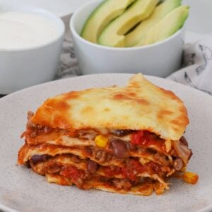 A healthy and delicious Mexican Lasagne recipe that the whole family will love... layered with tortilla wraps, a beefy bean taco mince and cheese!