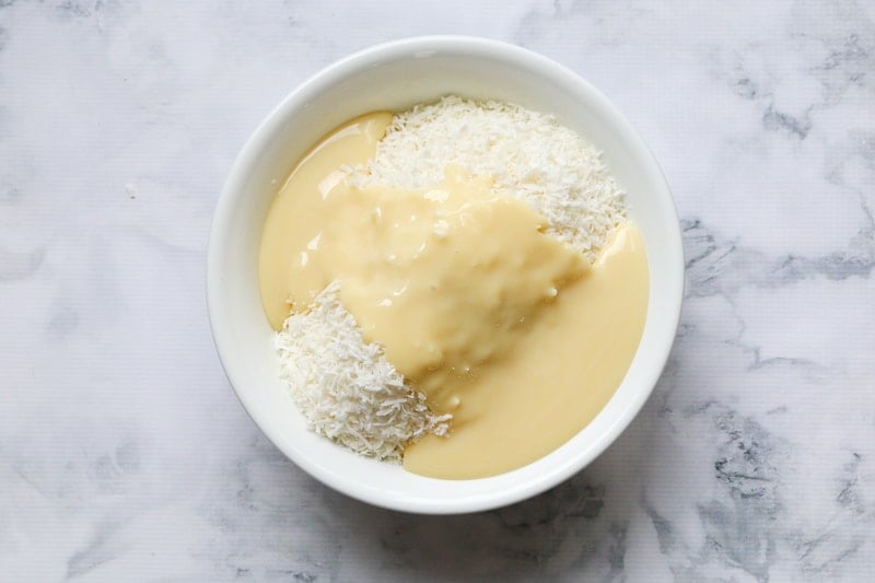 A bowl with coconut and condensed milk in it.