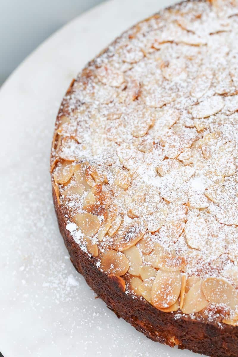 Icing sugar and flaked almonds on top of a cake. 