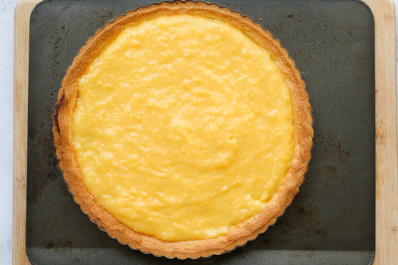 Lemon curd filling inside a shortcrust pastry shell.