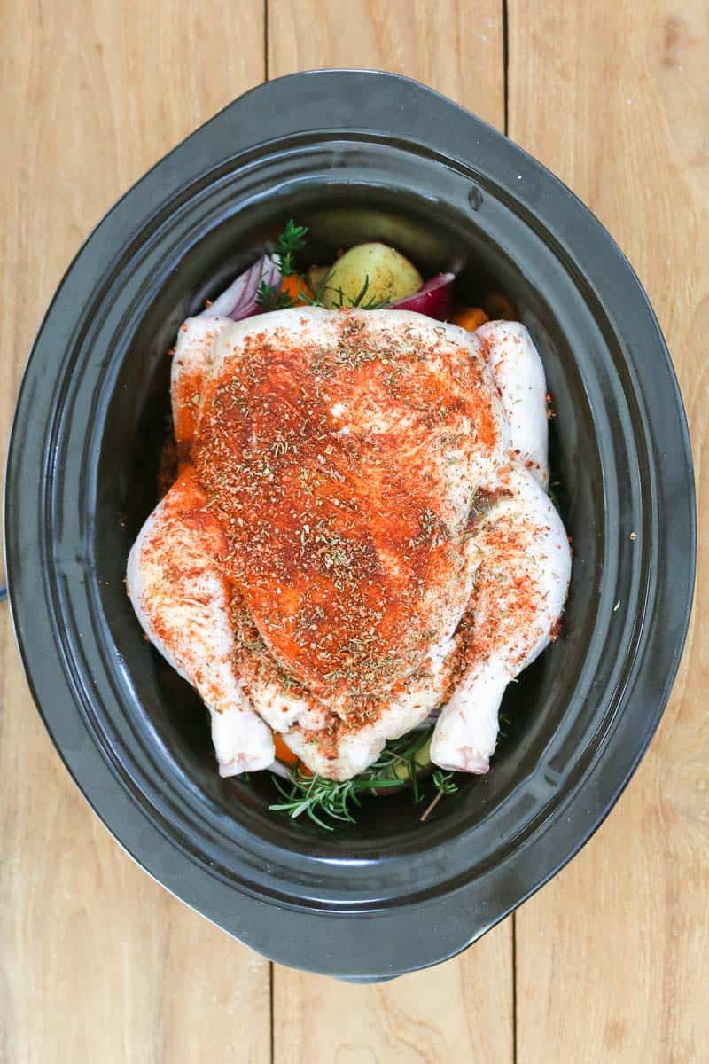 Seasoning added to a whole chicken in a slow cooker. 