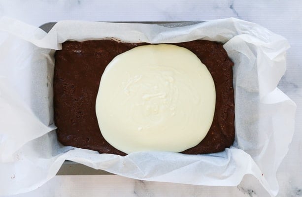 White chocolate poured over a chocolate slice.