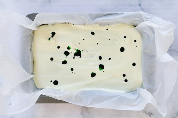 Green food colouring drops on top of white chocolate.