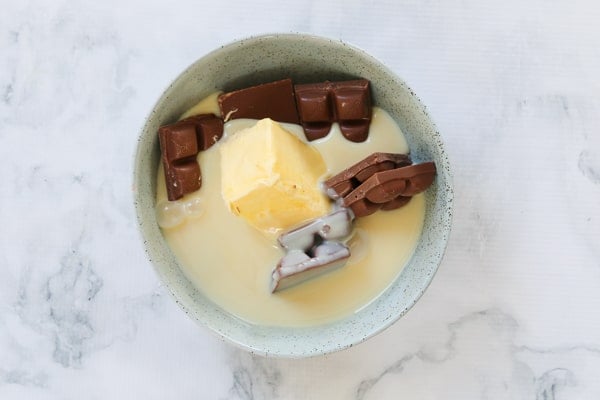 A bowl of chocolate, butter and condensed milk.