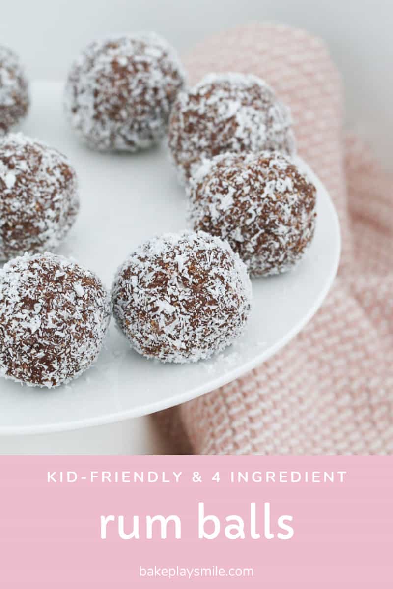 A white cake stand of rum balls next to a pink teatowel.